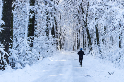 Man running in the forest in winter time